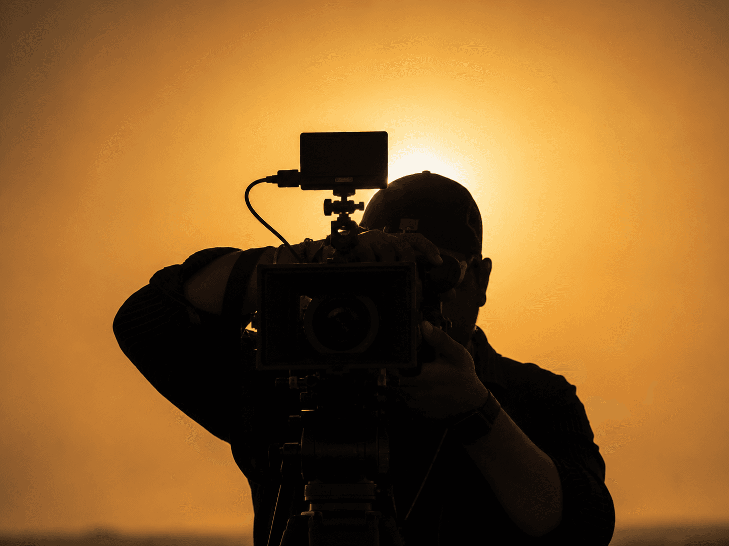 Filmmaker with cinema camera at golden hour